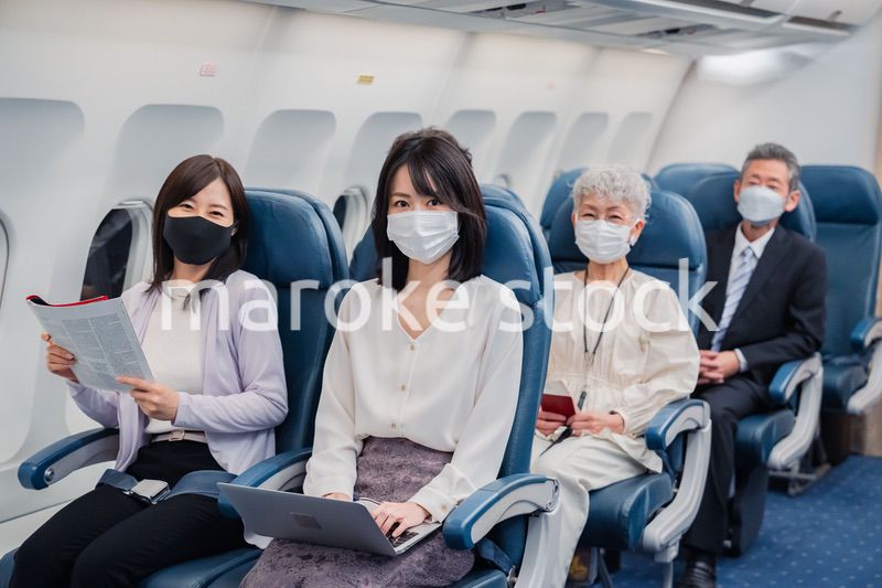 マスクをして飛行機に乗る乗客