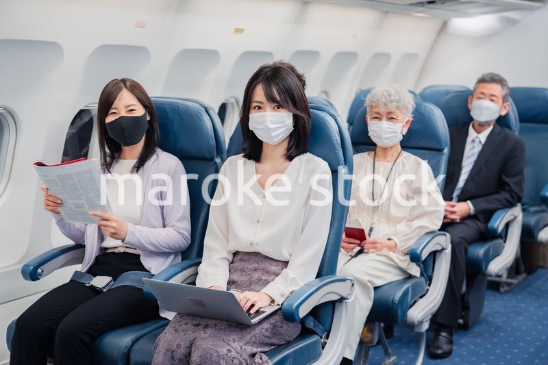 マスクをして飛行機に乗る乗客