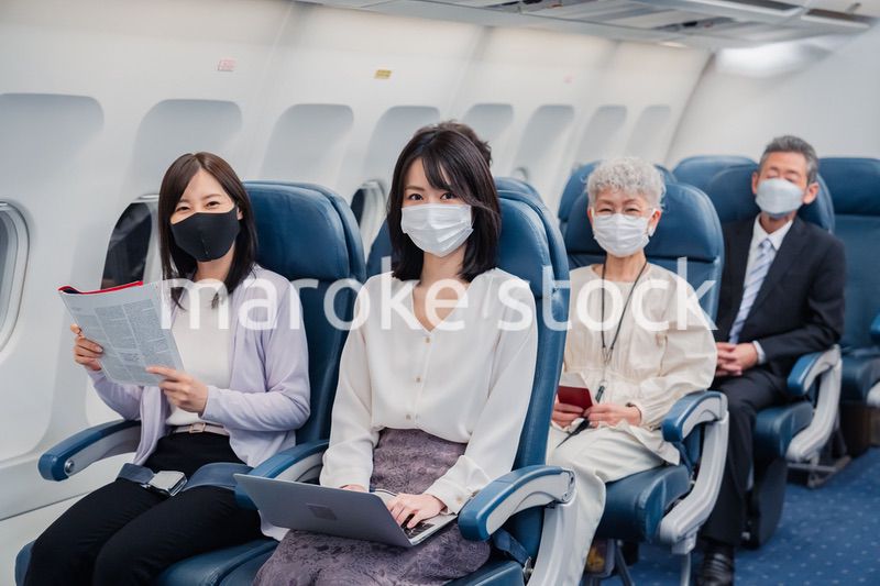 マスクをして飛行機に乗る乗客