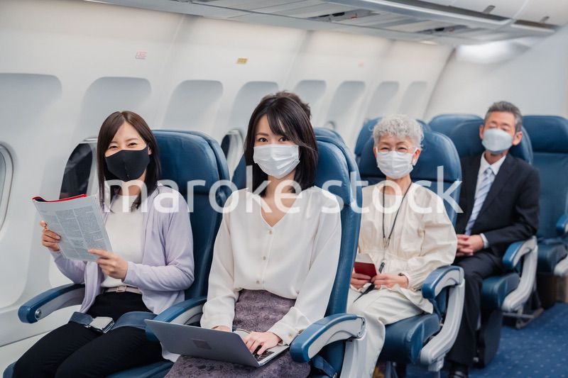 マスクをして飛行機に乗る乗客