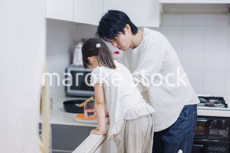 パパと一緒にクッキングをする小さな女の子