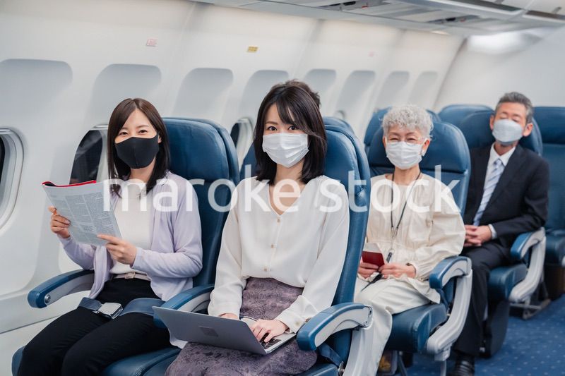 マスクをして飛行機に乗る乗客
