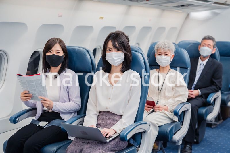 マスクをして飛行機に乗る乗客