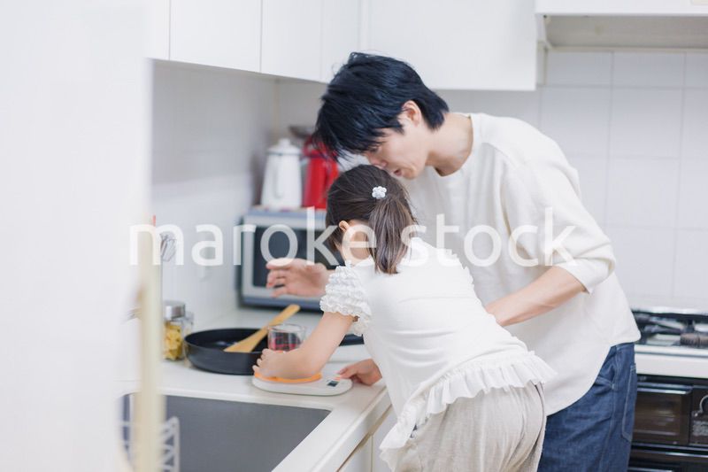 パパと一緒にクッキングをする小さな女の子