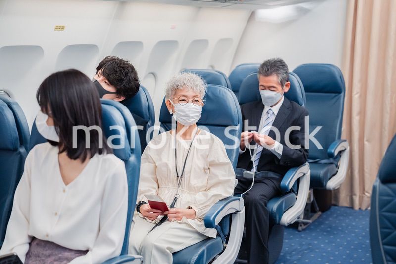 マスクをして飛行機に乗る乗客