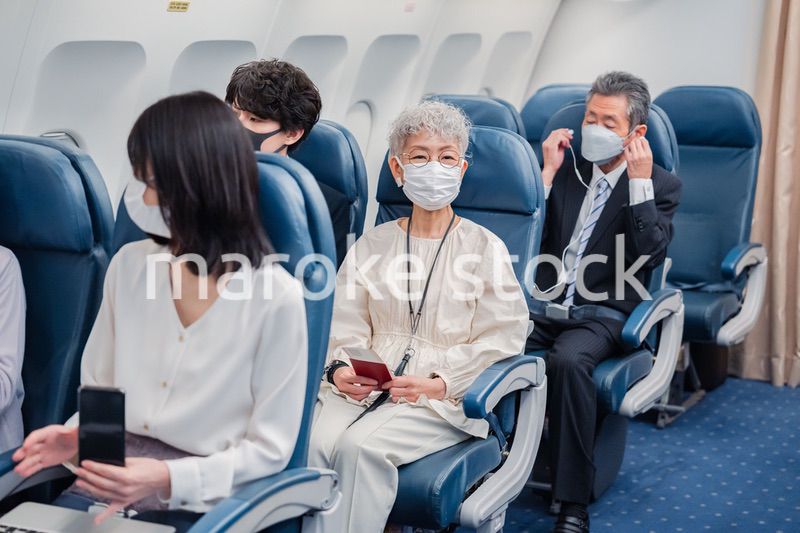 マスクをして飛行機に乗る乗客