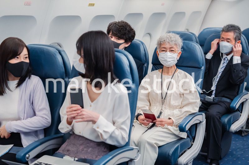 マスクをして飛行機に乗る乗客