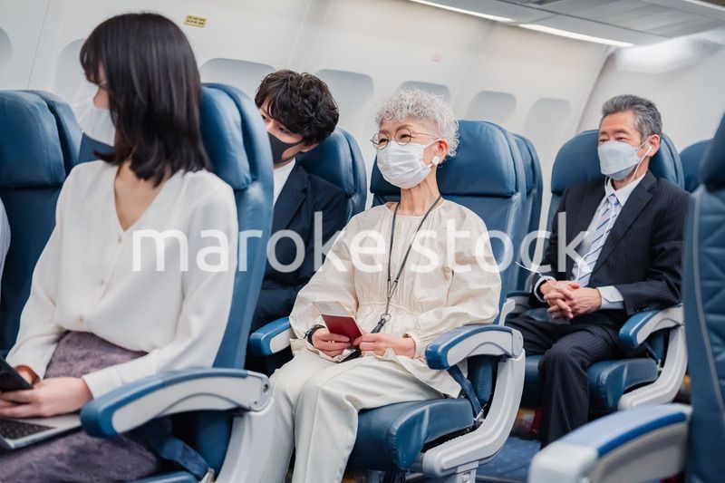 マスクをして飛行機に乗る乗客