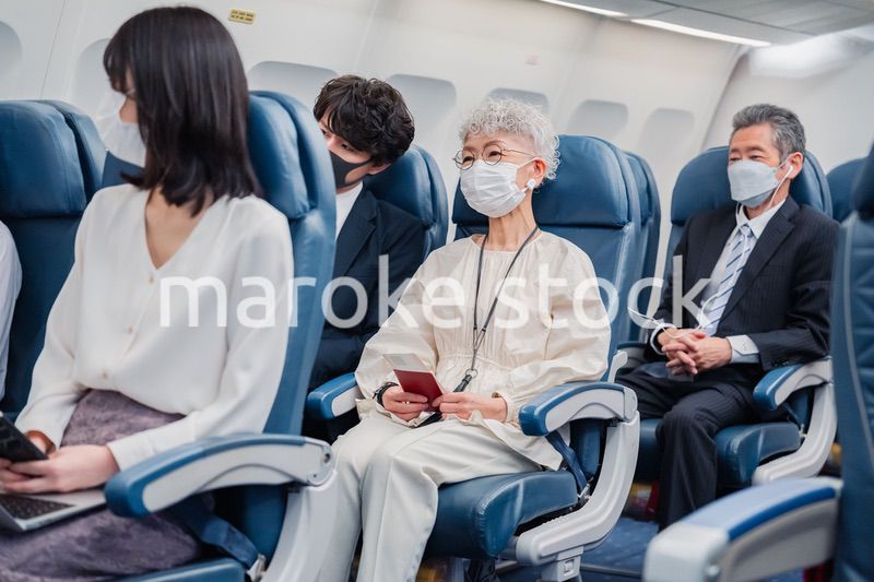 マスクをして飛行機に乗る乗客