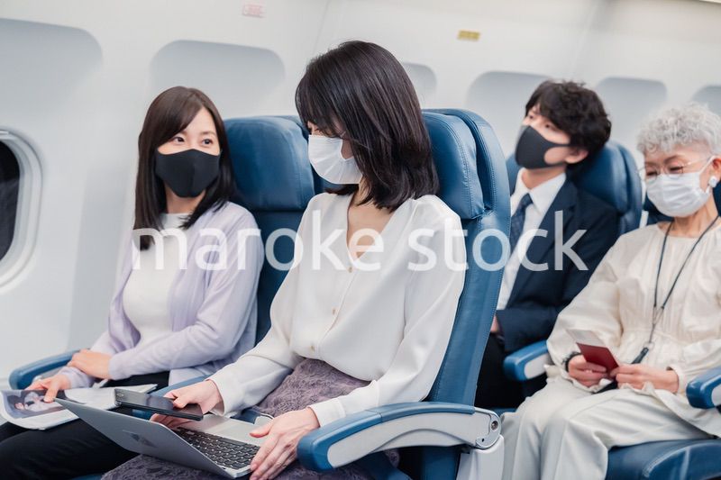 マスクをして飛行機に乗る乗客