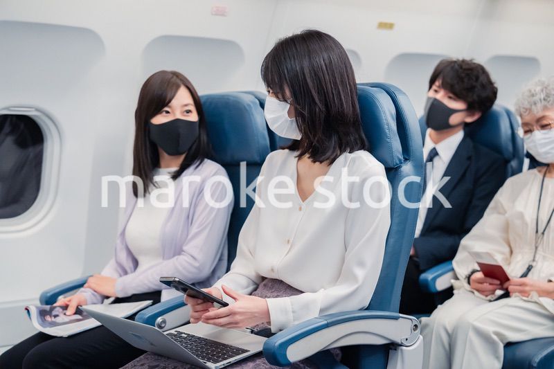 マスクをして飛行機に乗る乗客