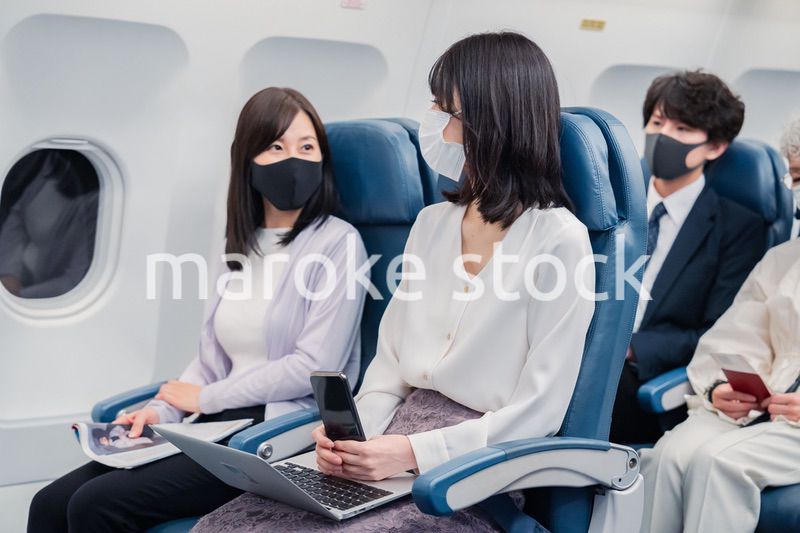 マスクをして飛行機に乗る乗客