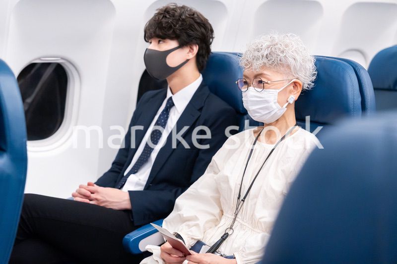 マスクをして飛行機に乗る乗客