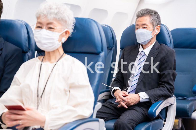 マスクをして飛行機に乗る乗客