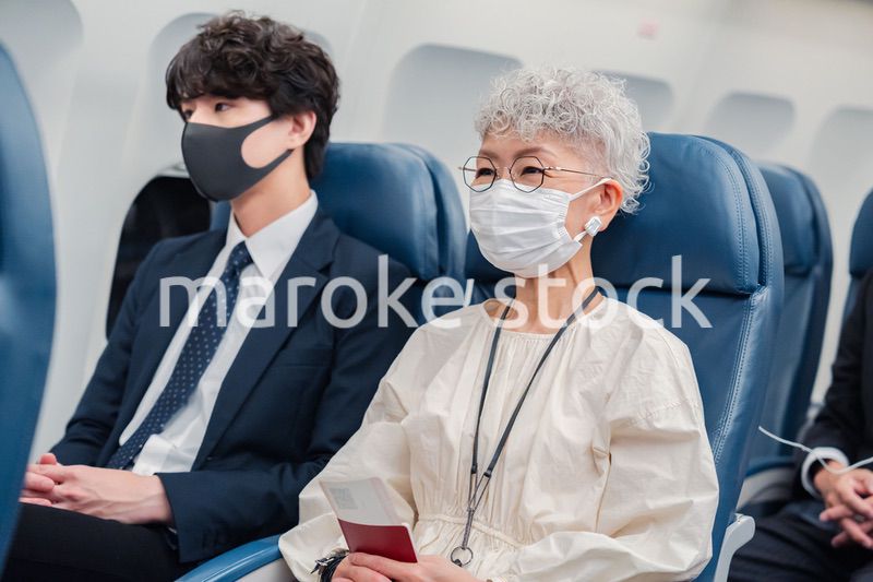 飛行機で旅行をする高齢の女性