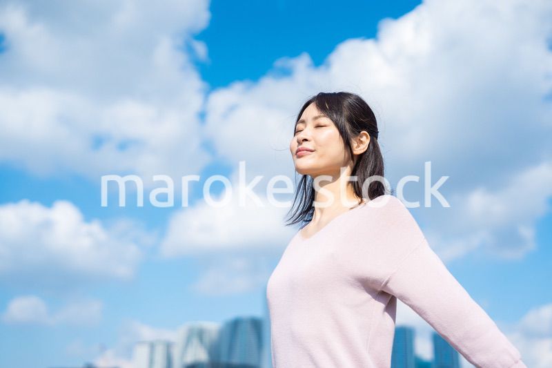 外で深呼吸をする若いビジネスウーマン