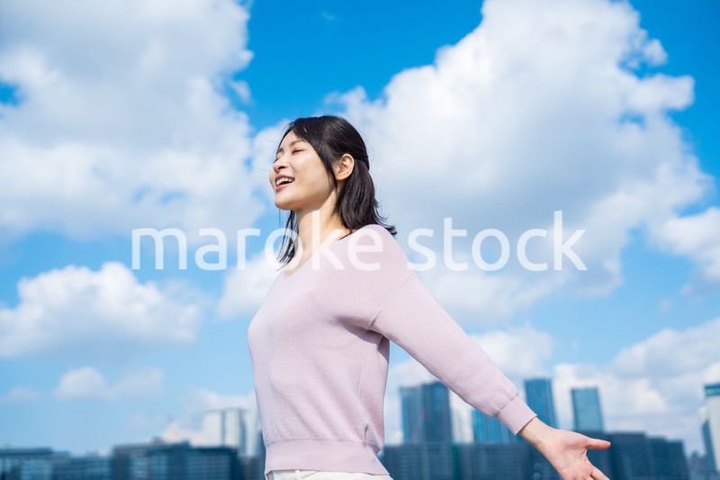 外で深呼吸をする若いビジネスウーマン