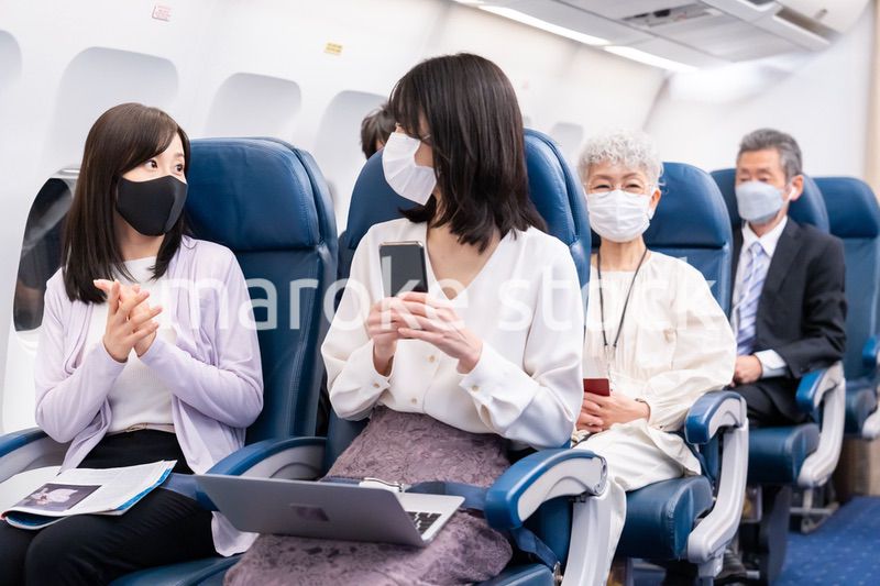 マスクをして飛行機に乗る乗客