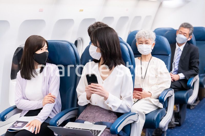 マスクをして飛行機に乗る乗客