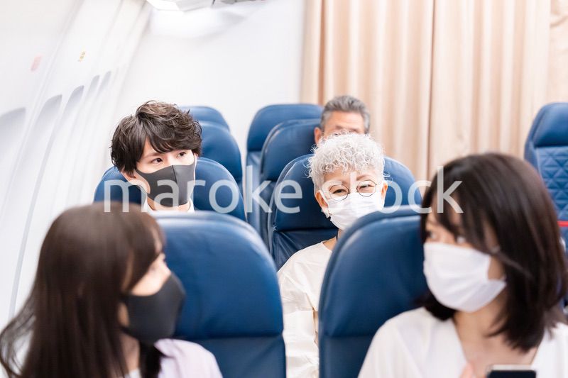 マスクをして飛行機に乗る乗客