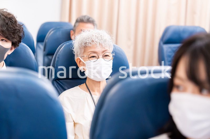 マスクをして飛行機に乗る乗客
