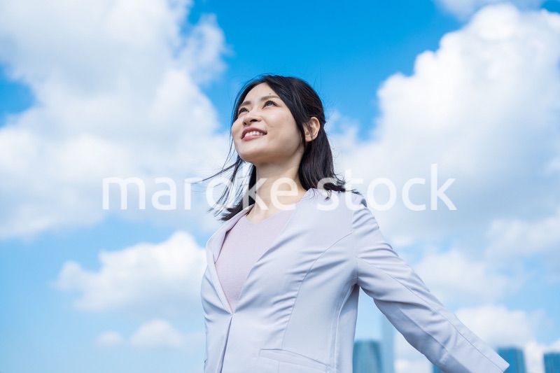 外で深呼吸をする若いビジネスウーマン