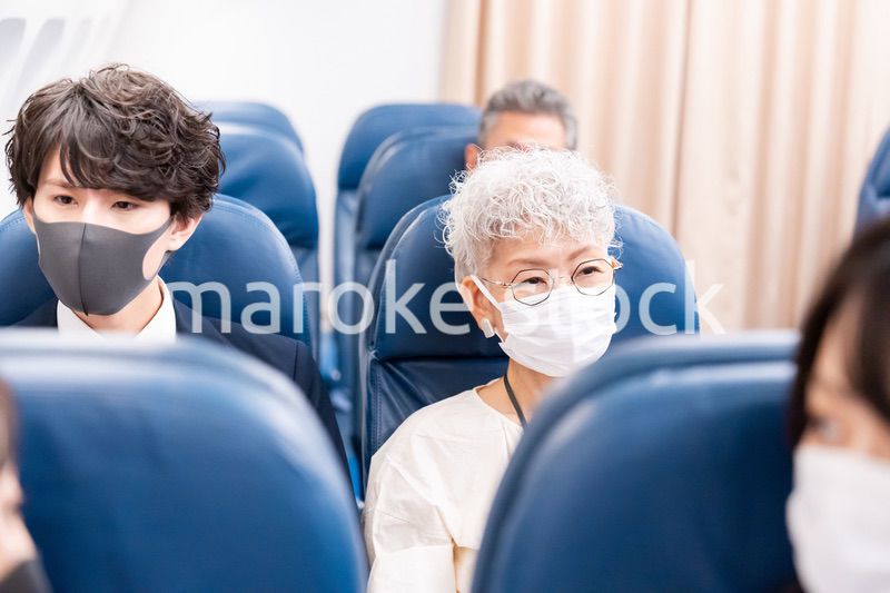 マスクをして飛行機に乗る乗客