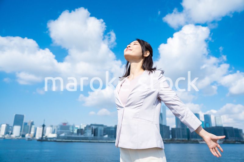 外で深呼吸をする若いビジネスウーマン