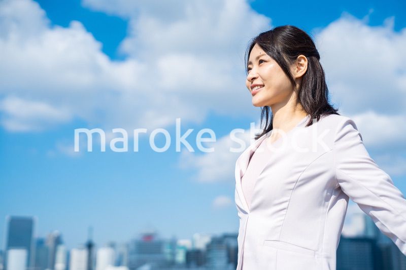 外で深呼吸をする若いビジネスウーマン