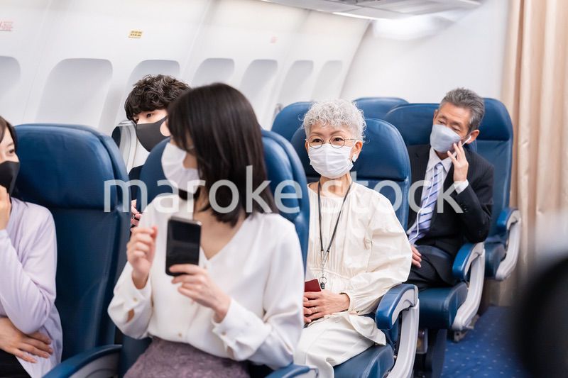 マスクをして飛行機に乗る乗客