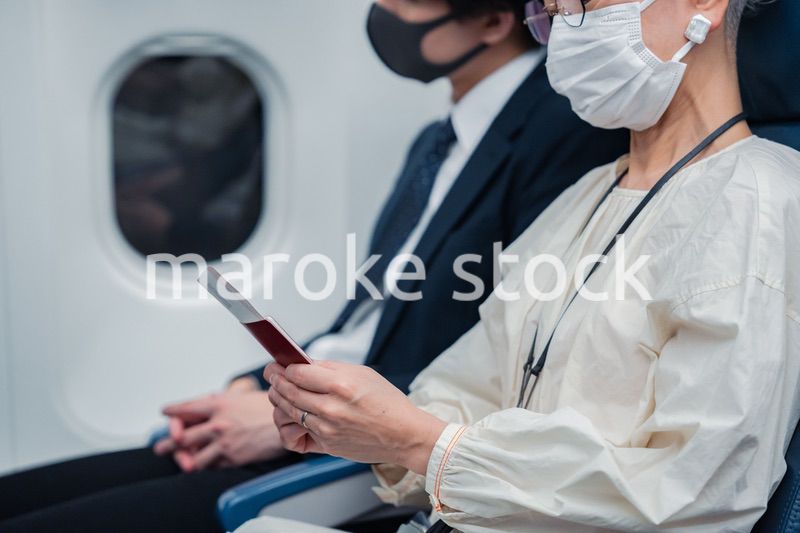 飛行機で旅行をする高齢の女性