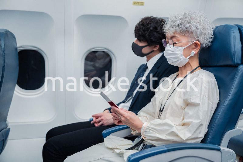 飛行機で旅行をする高齢の女性