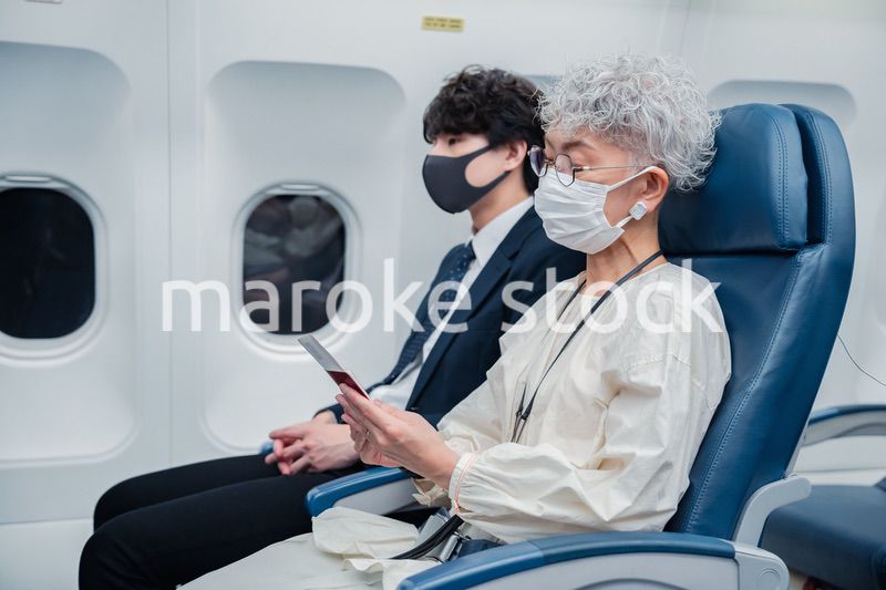 飛行機で旅行をする高齢の女性