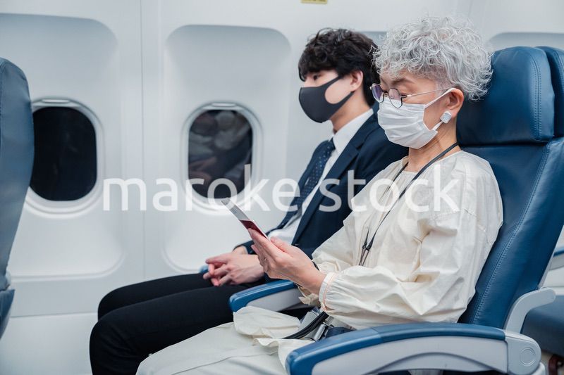 飛行機で旅行をする高齢の女性