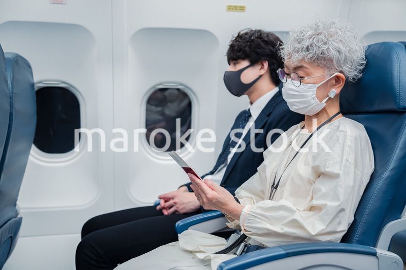 飛行機で旅行をする高齢の女性