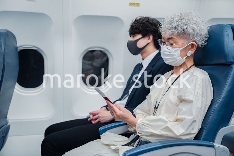 飛行機で旅行をする高齢の女性