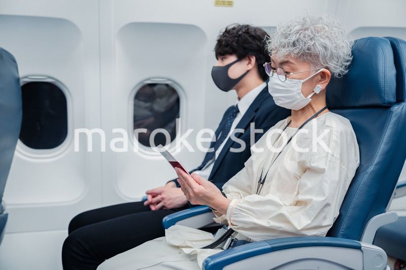 飛行機で旅行をする高齢の女性