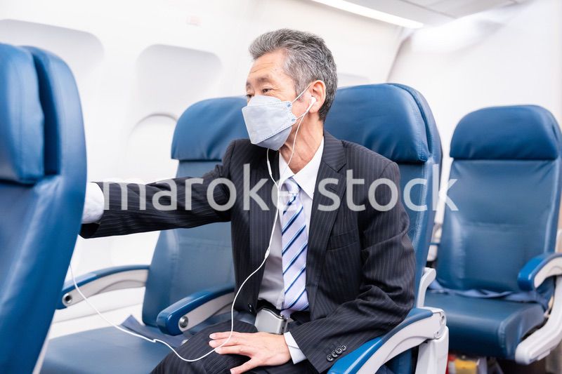 マスクをして飛行機に乗る乗客