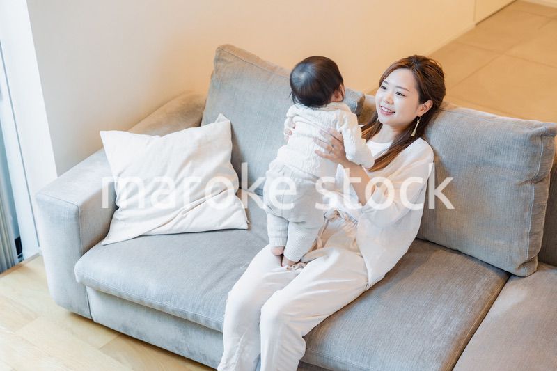 おうちで赤ちゃんに高い高いをするお母さん