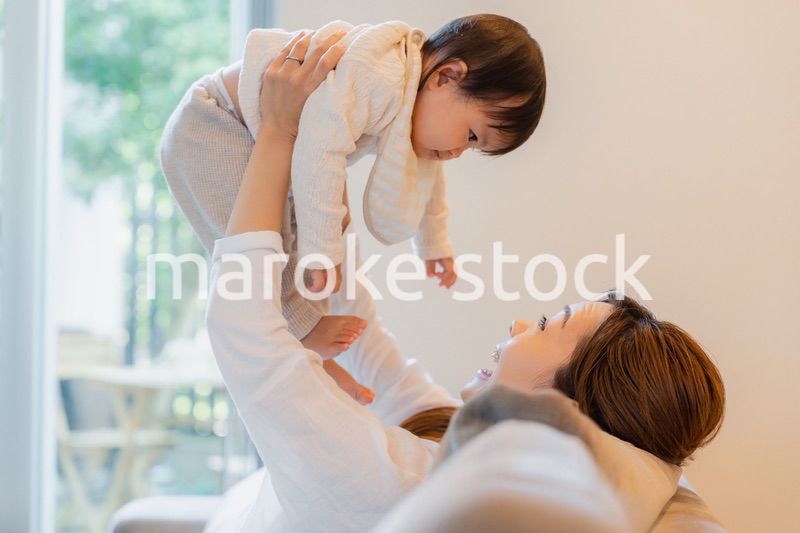 おうちで赤ちゃんに高い高いをするお母さん