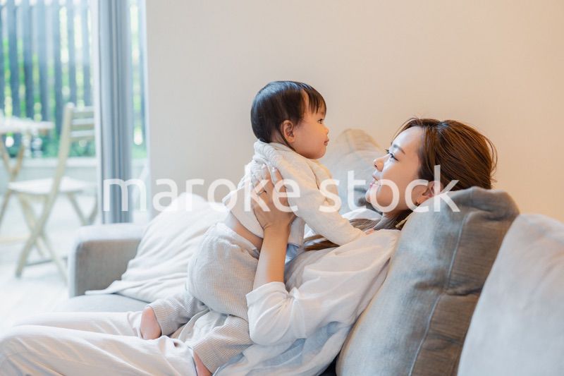 おうちで赤ちゃんに高い高いをするお母さん