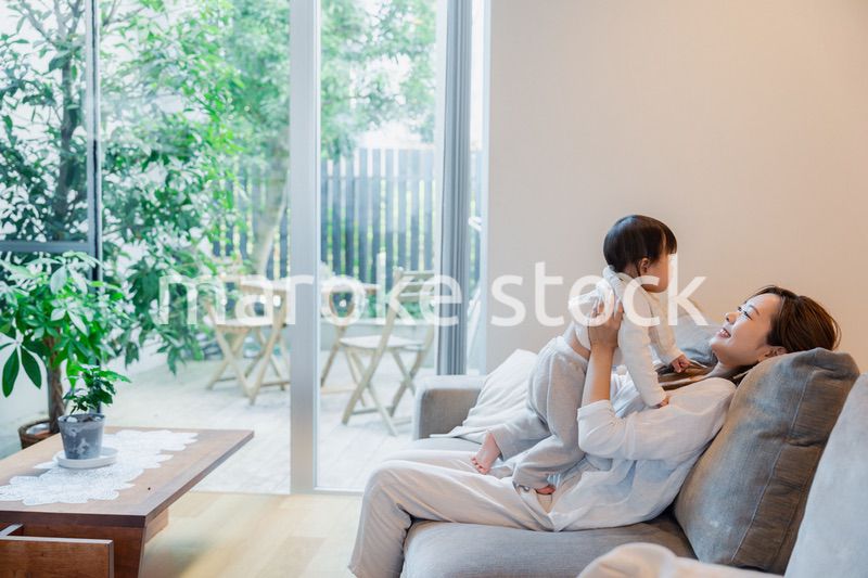 おうちで赤ちゃんに高い高いをするお母さん