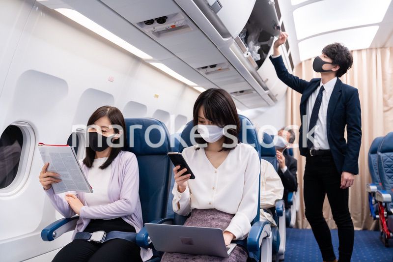 マスクをして飛行機に乗る乗客