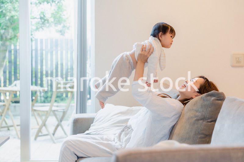 おうちで赤ちゃんに高い高いをするお母さん