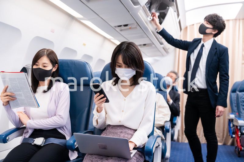 マスクをして飛行機に乗る乗客