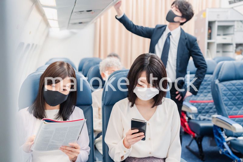 飛行機の機内で過ごす乗客