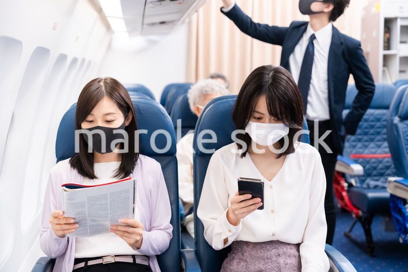 マスクをして飛行機に乗る乗客