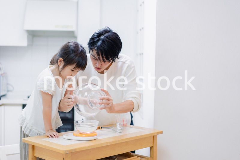 パパと一緒にクッキングをする小さな女の子