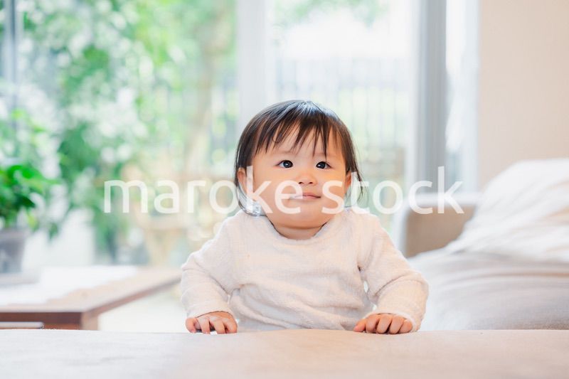 家でつかまり立ちをする赤ちゃん