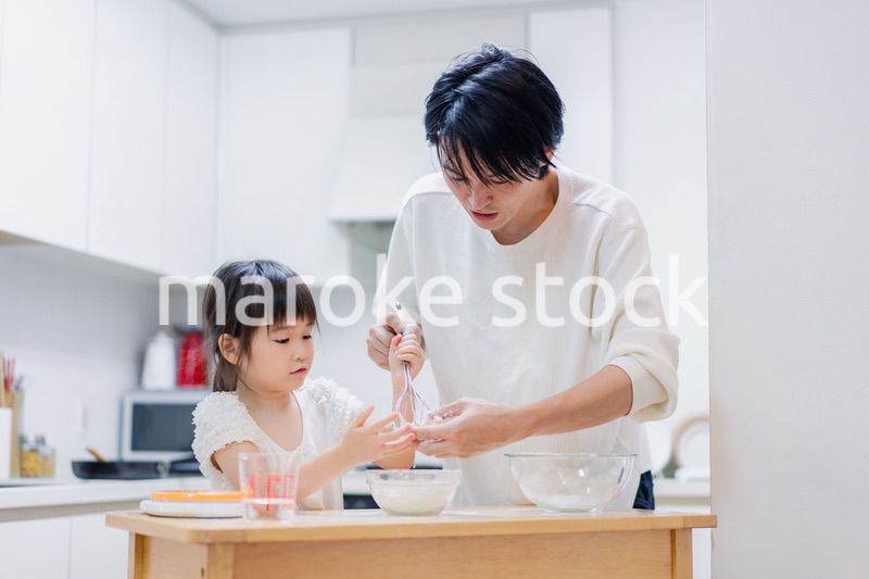 パパと一緒にクッキングをする小さな女の子